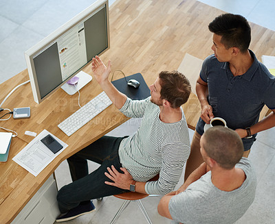 Buy stock photo High angle shot of three designers working together on a project in an office