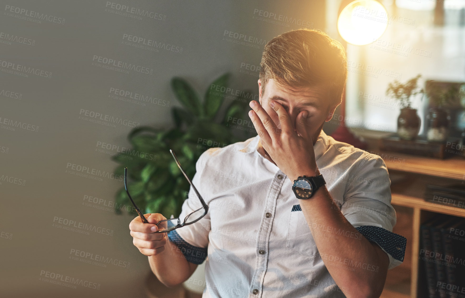 Buy stock photo Shot of a young designer looking exhausted on his night shift