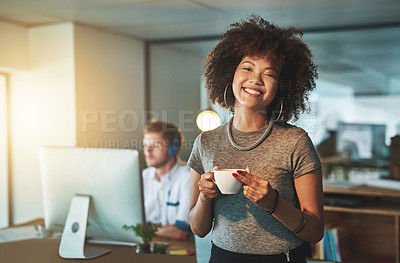 Buy stock photo Portrait of a young designer working late with her colleague blurred in the background