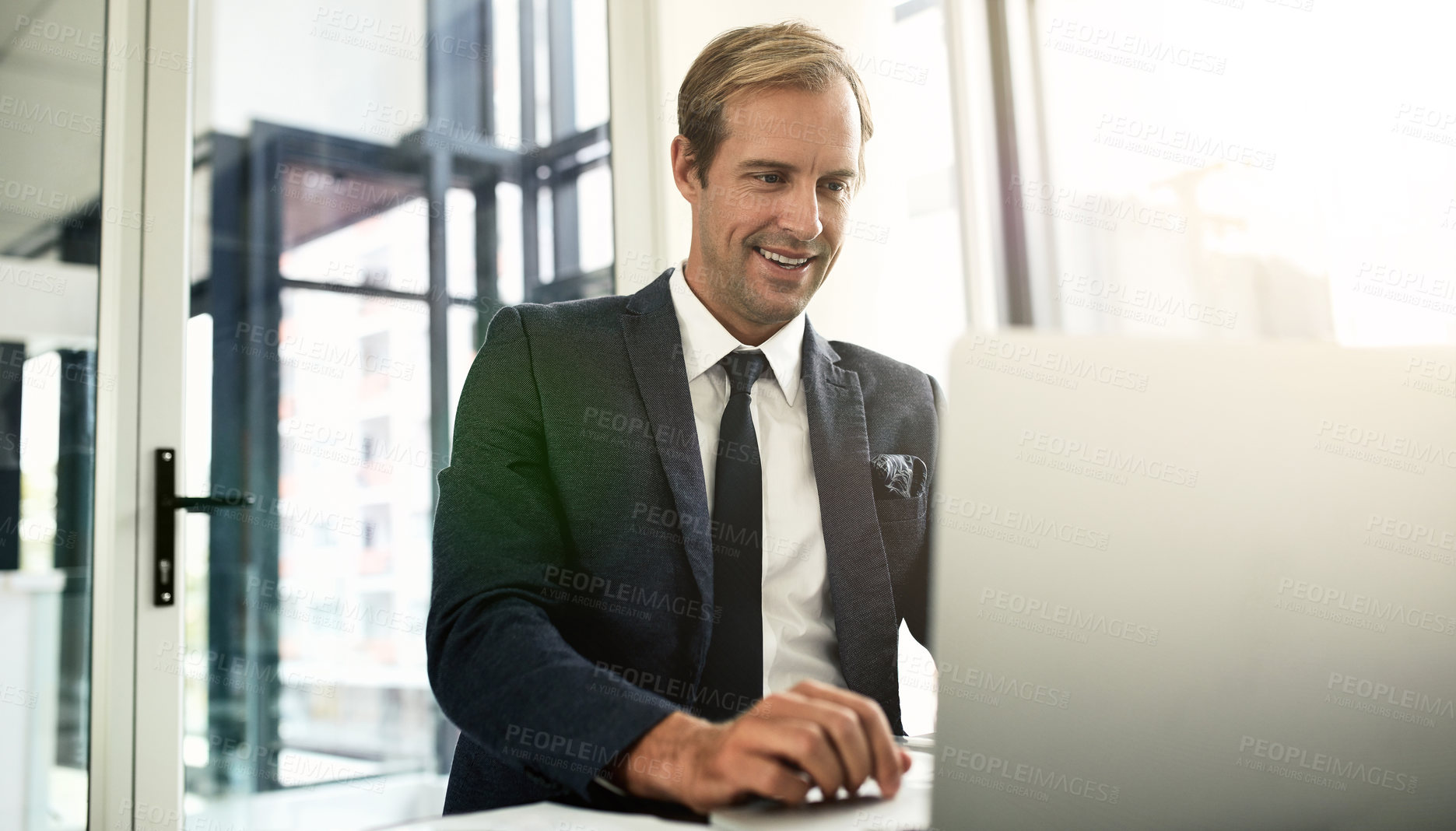 Buy stock photo Shot of a businessman using his laptop