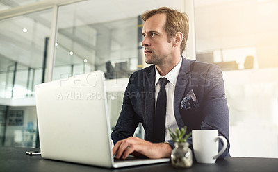 Buy stock photo Shot of a businessman looking thoughtful while using his laptop