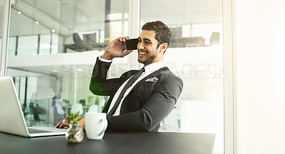 Buy stock photo Shot of a businessman talking on his cellphone while looking at his laptop