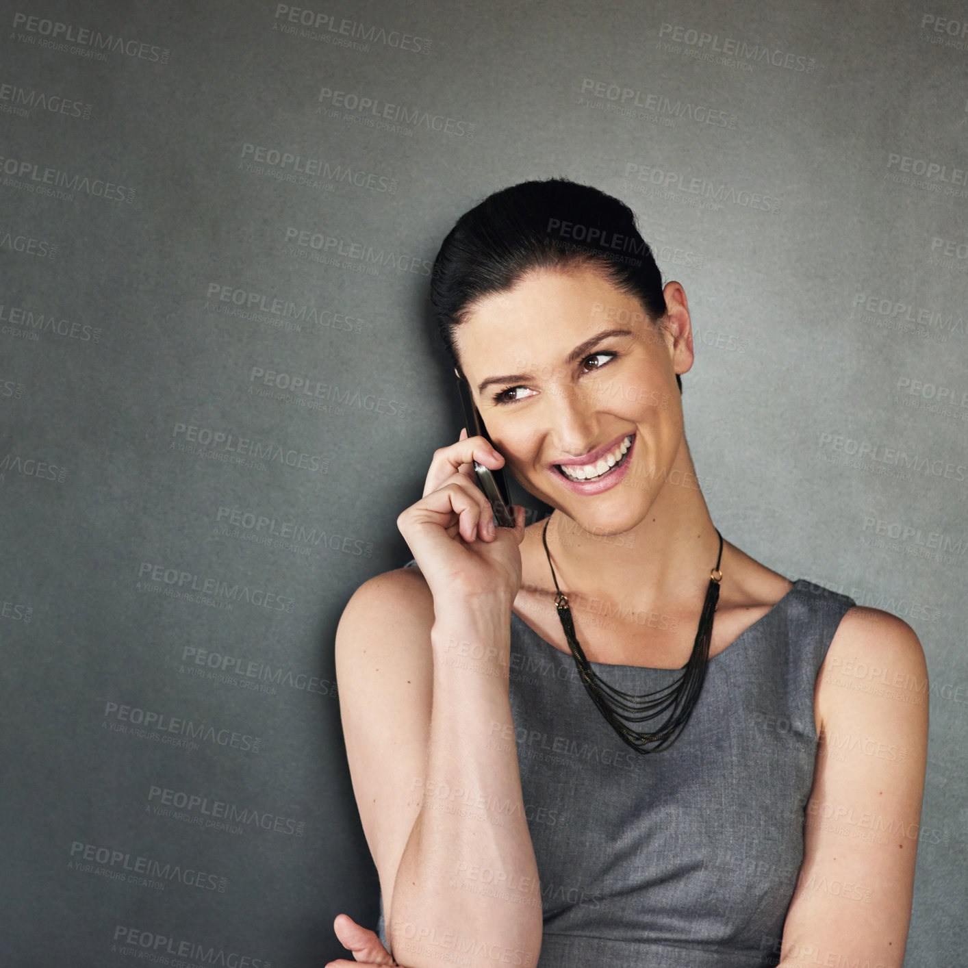 Buy stock photo Studio shot of a businesswoman using her cellphone against a grey background