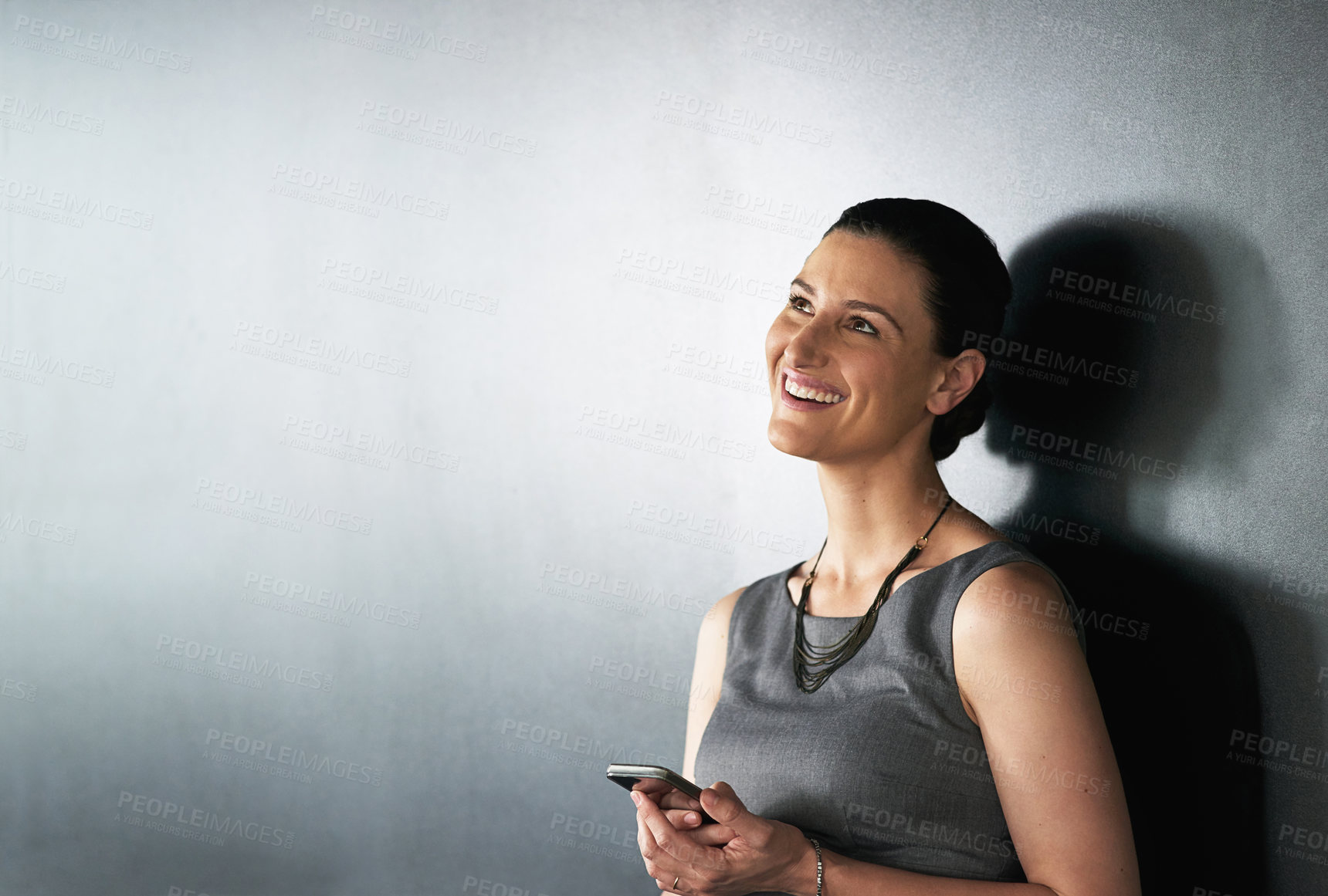 Buy stock photo Studio shot of a businesswoman using her cellphone against a grey background