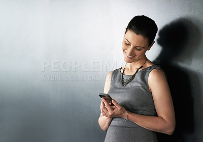 Buy stock photo Happy, business woman and social media with phone in studio for communication or chat on gray background. Female person, employee or model with smile, mobile smartphone or text app on mockup space