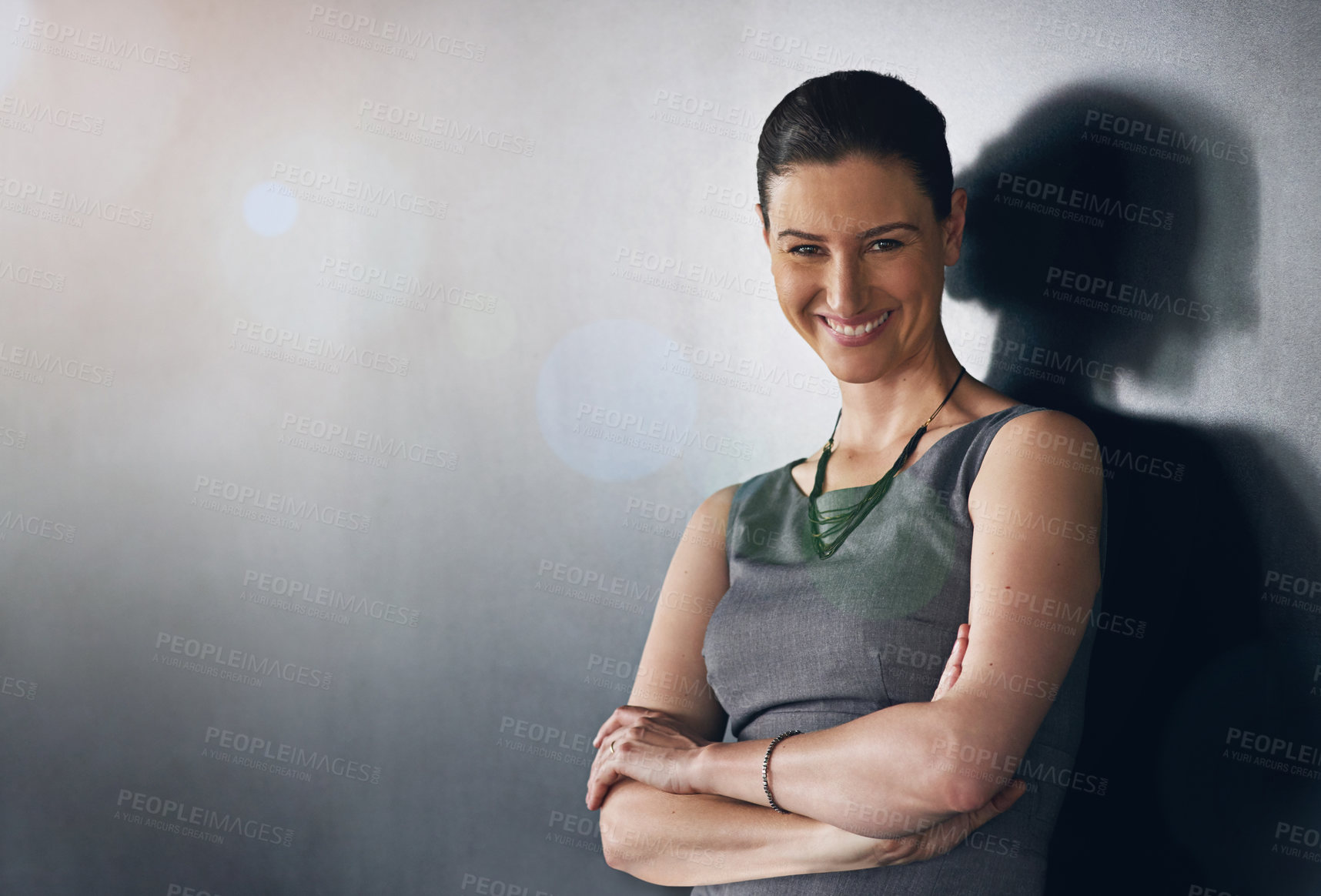 Buy stock photo Studio portrait of a businesswoman standing with her arms folded against a grey background