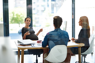 Buy stock photo Shot of a pregnant businesswoman having a meeting with colleagues in office
