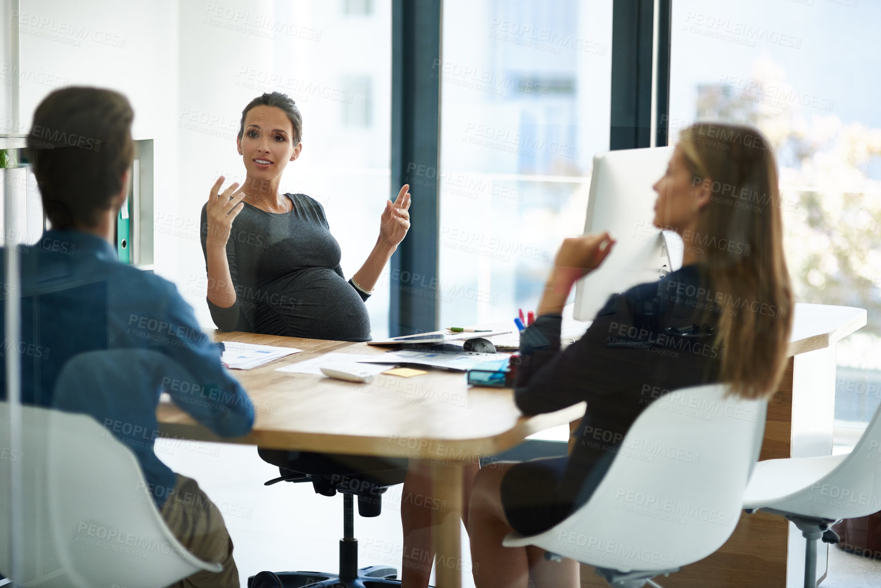 Buy stock photo Shot of a pregnant businesswoman having a meeting with colleagues in office