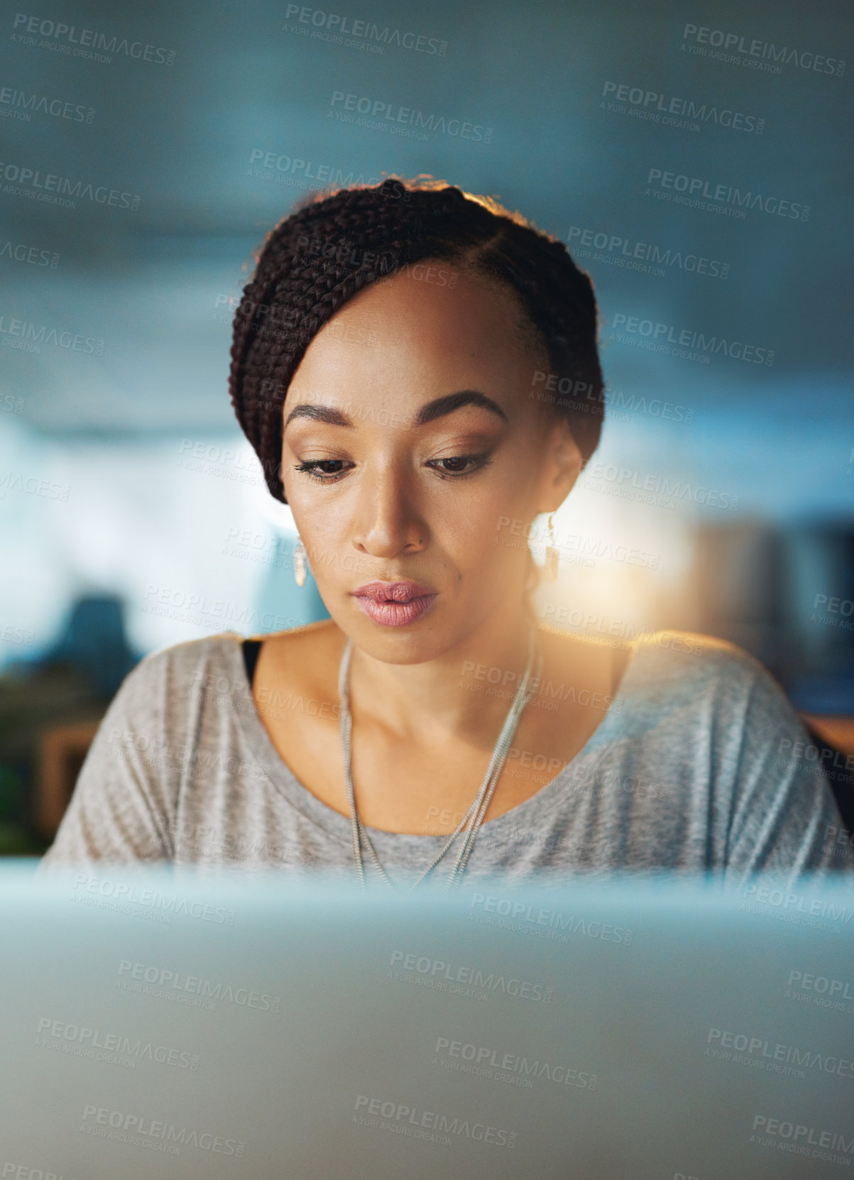 Buy stock photo Cropped shot of a young woman using her laptop while working late in her office