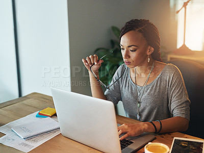 Buy stock photo Cropped shot of a young woman using her laptop while working late in her office