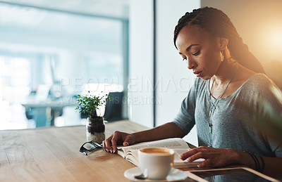 Buy stock photo Cropped shot of a young woman reading a book while working late in her office