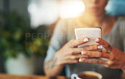 Buy stock photo Cropped shot of a young woman sending an sms while working late in her office