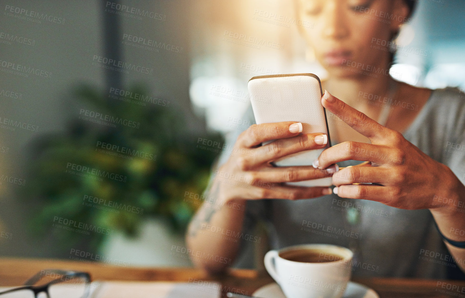 Buy stock photo Cropped shot of a young woman sending an sms while working late in her office