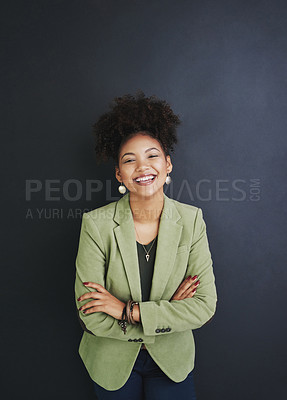 Buy stock photo Studio shot of a young woman standing against a dark background