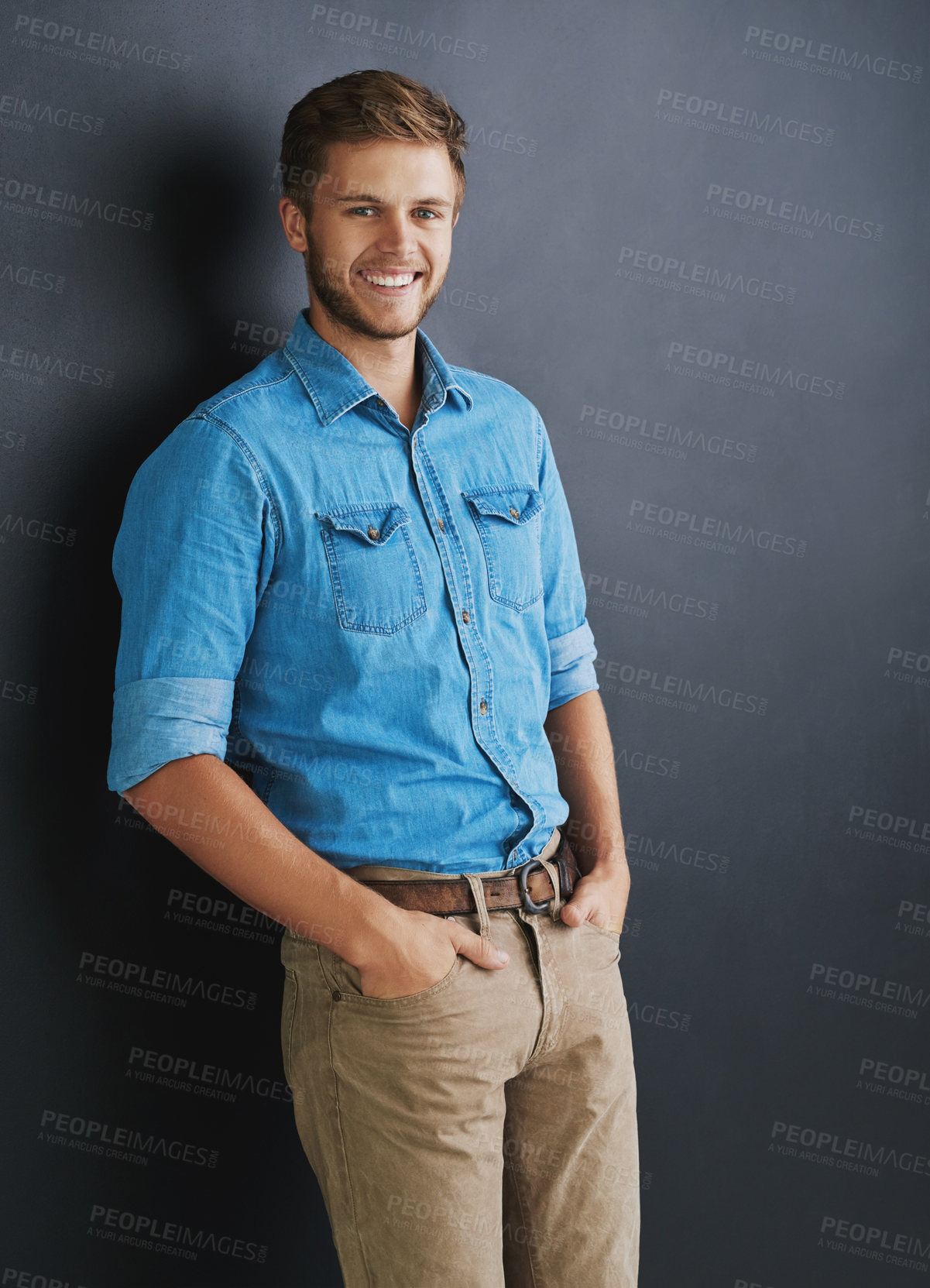 Buy stock photo Studio shot of a young man standing against a dark background