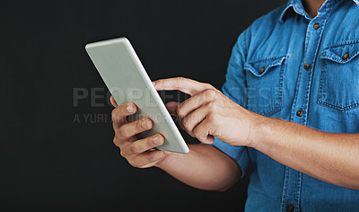 Buy stock photo Studio shot of a young man  using a digital tablet