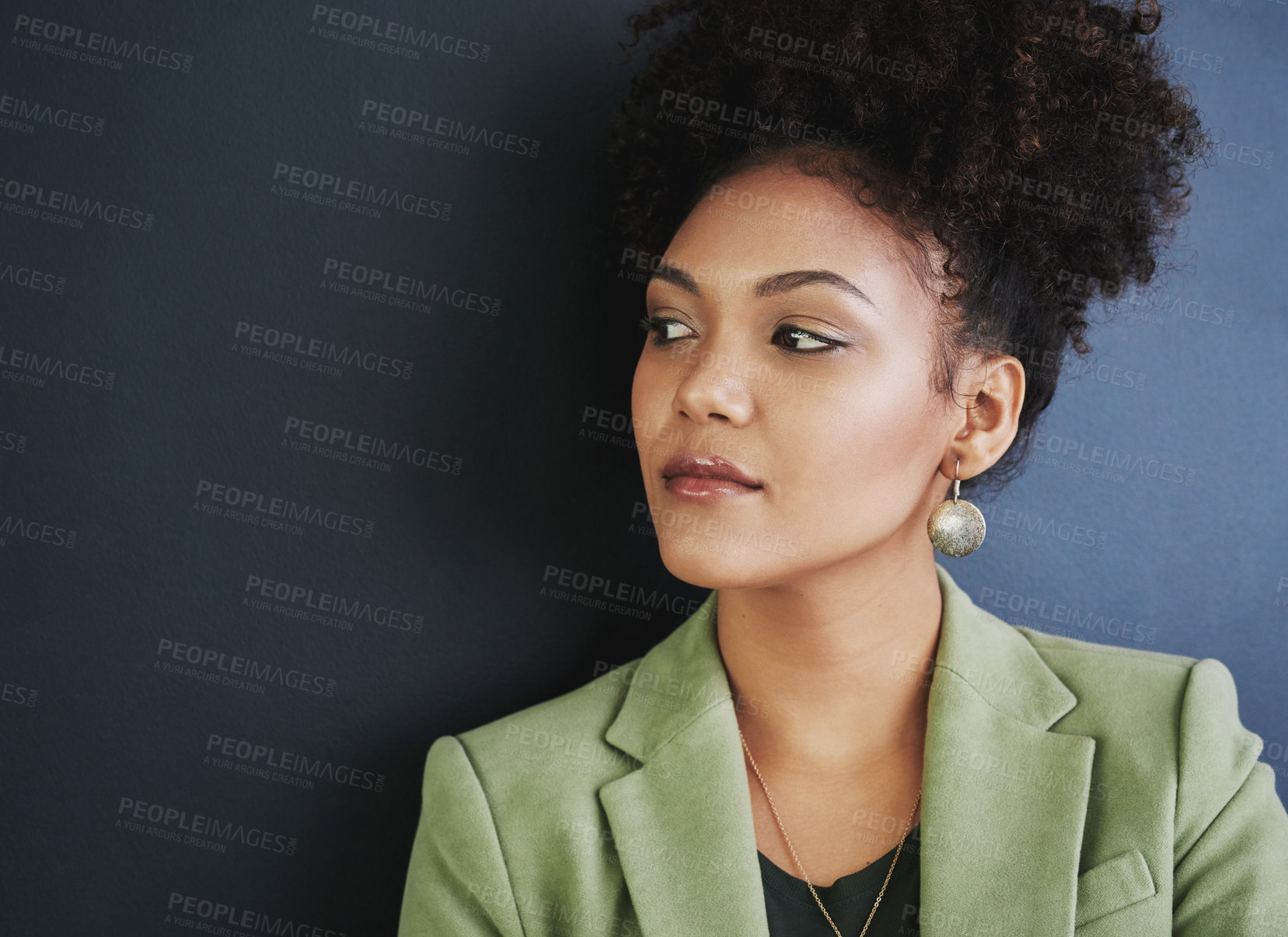 Buy stock photo Studio shot of a young woman standing against a dark background