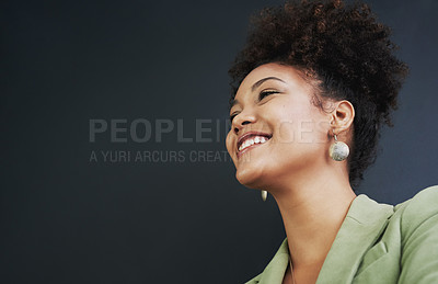 Buy stock photo Studio shot of a young woman standing against a dark background