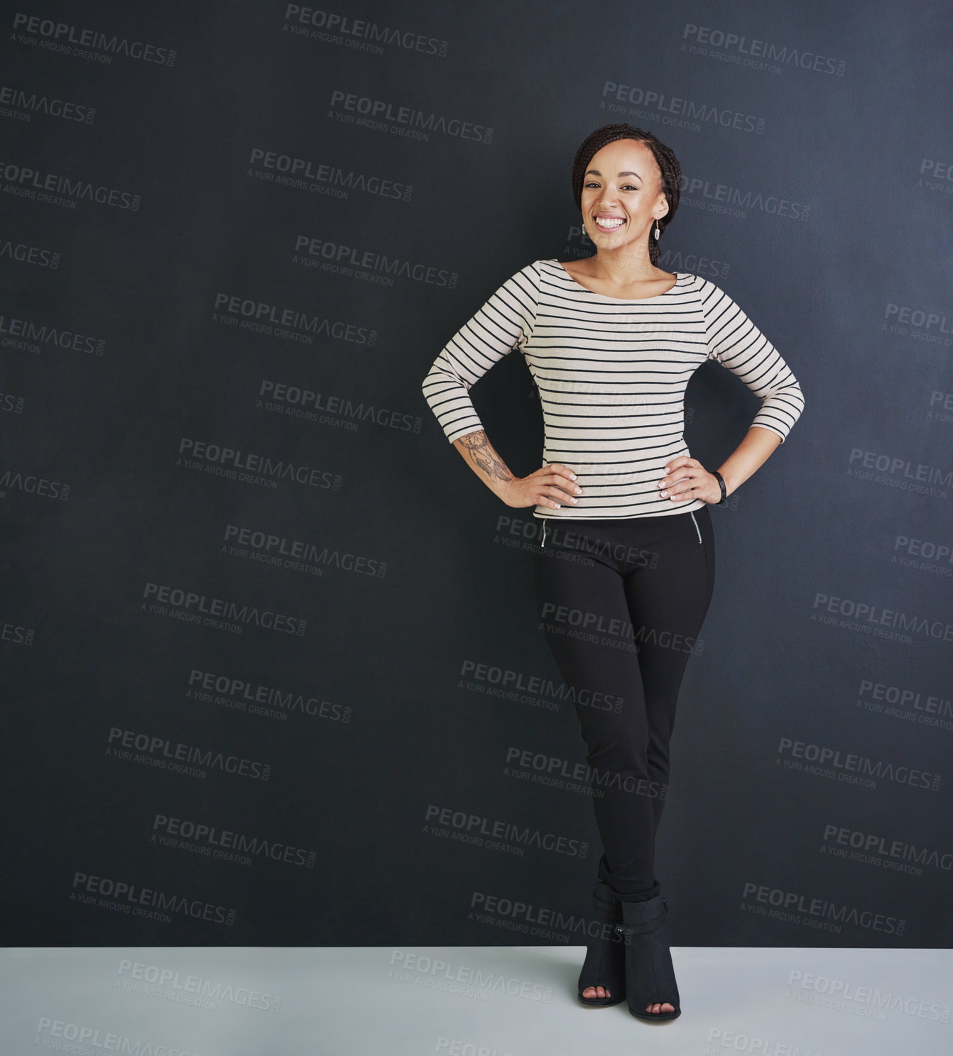 Buy stock photo Studio shot of a young woman standing against a dark background