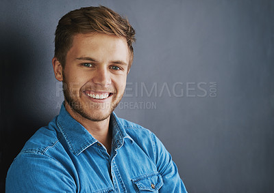 Buy stock photo Studio shot of a young man standing against a dark background