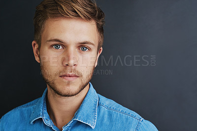 Buy stock photo Studio shot of a young man standing against a dark background