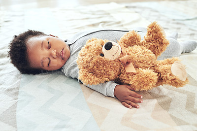 Buy stock photo Shot of a little baby boy sleeping on the floor with his teddy bear