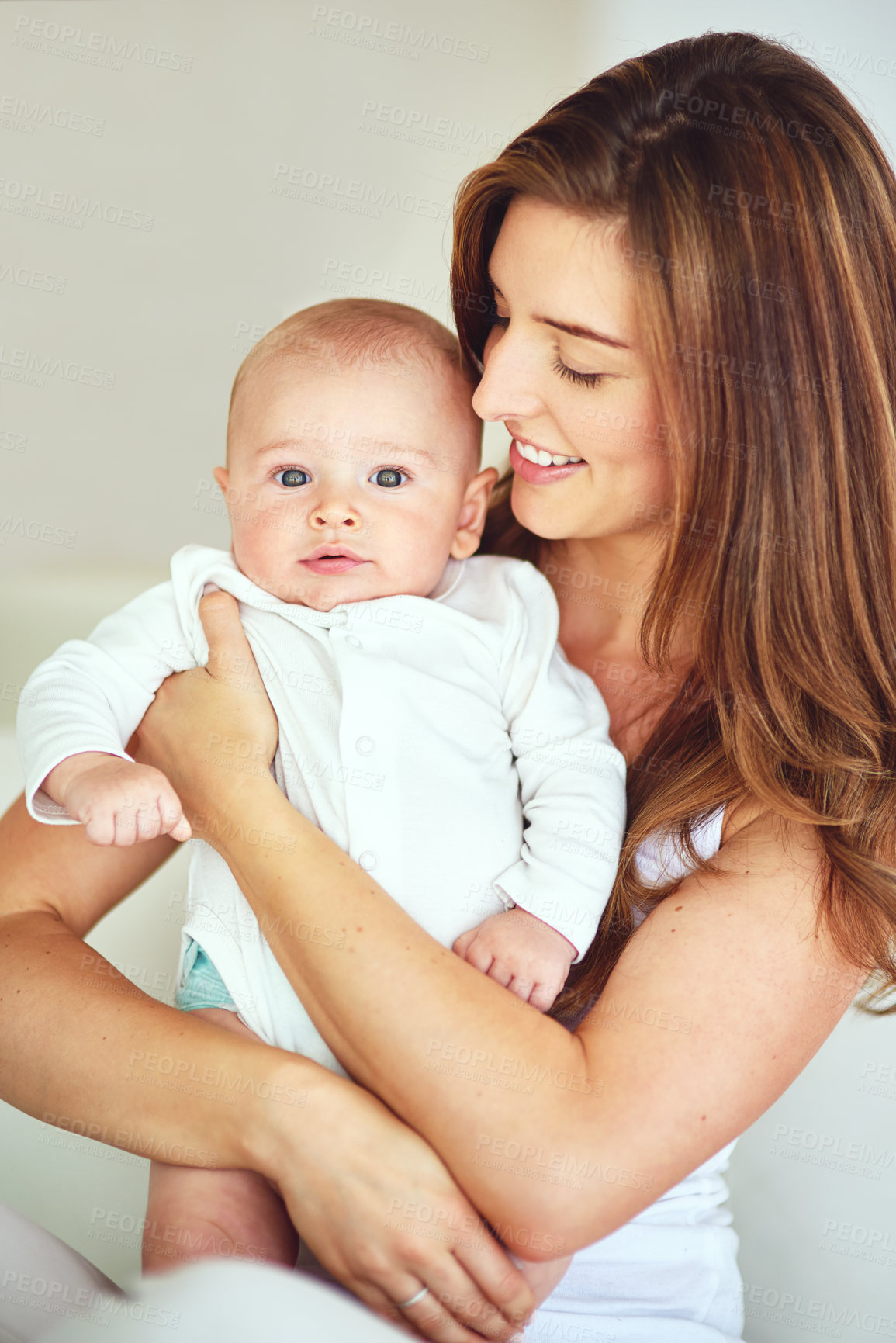 Buy stock photo Beautiful family portrait of mother and baby boy hugging, bonding at home, carefree and loving. Smiling, cheerful parent embracing her newborn, enjoying the bond of parenthood and excited to be a mom