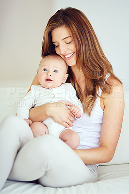 Buy stock photo Shot of a young mother bonding with her adorable baby boy at home