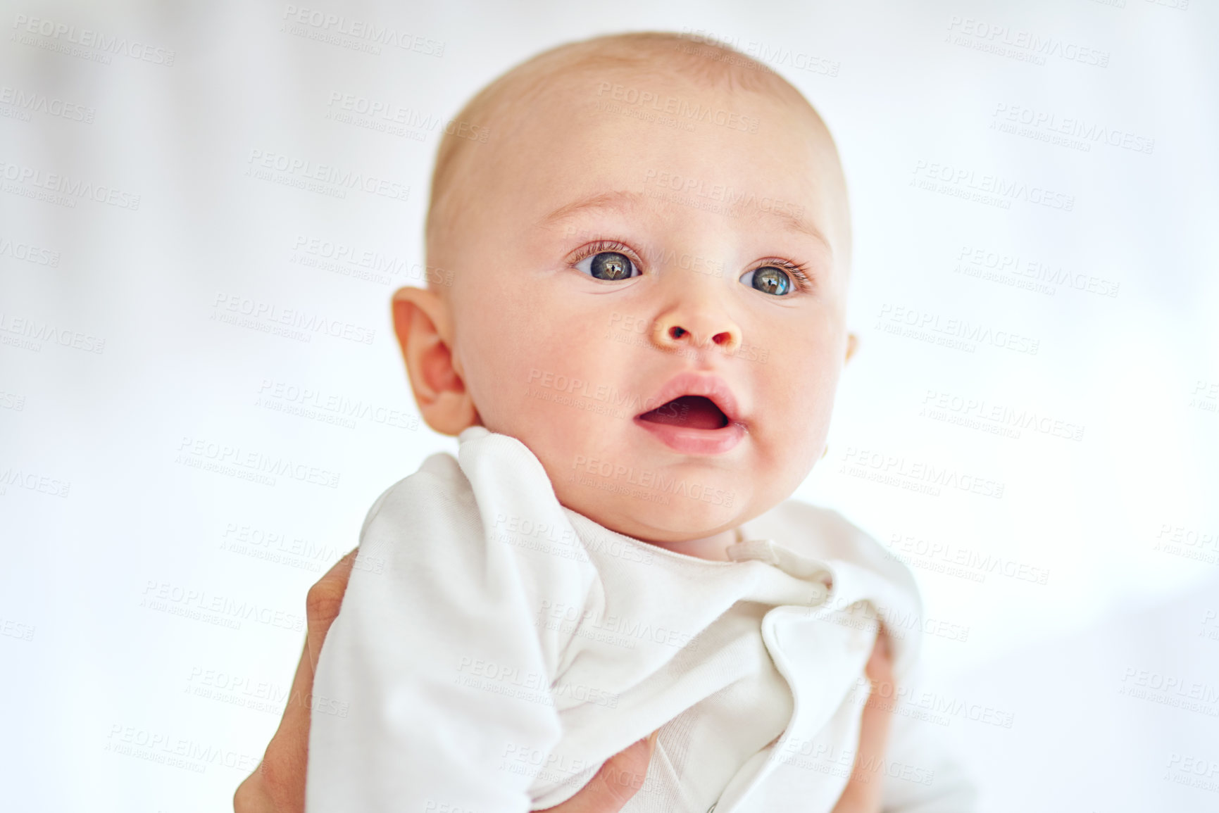 Buy stock photo Adorable, curious and face of baby in home with parent for child development, growth or wonder. Cute, innocent and sweet with person lifting infant in apartment for family security, future or love