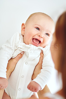 Buy stock photo Shot of a loving mother carrying her baby boy at home