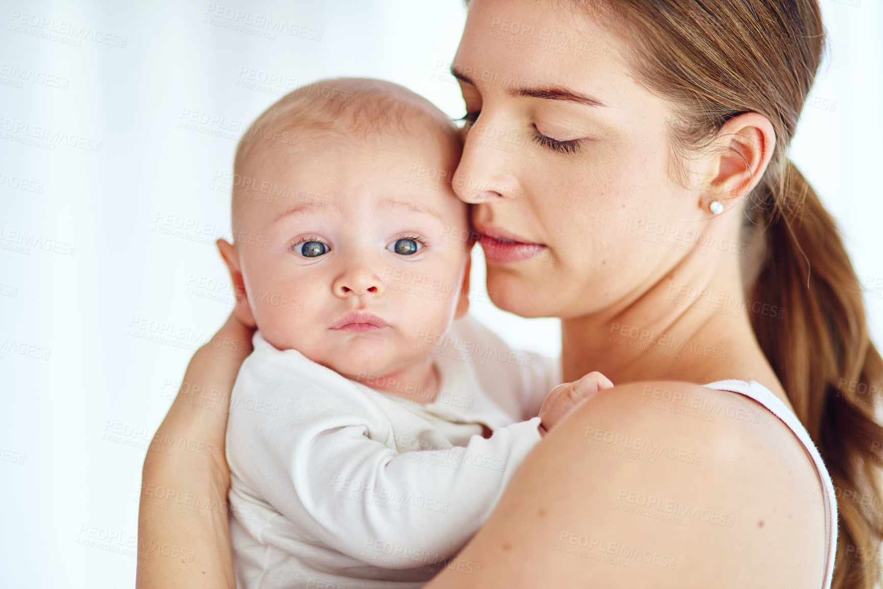 Buy stock photo Shot of a loving mother carrying her baby boy at home