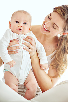 Buy stock photo Portrait a happy mother bonding with her cute baby boy at home, enjoying fun moments of parenthood. Young female being affectionate and loving with her newborn, playing and spending time together
