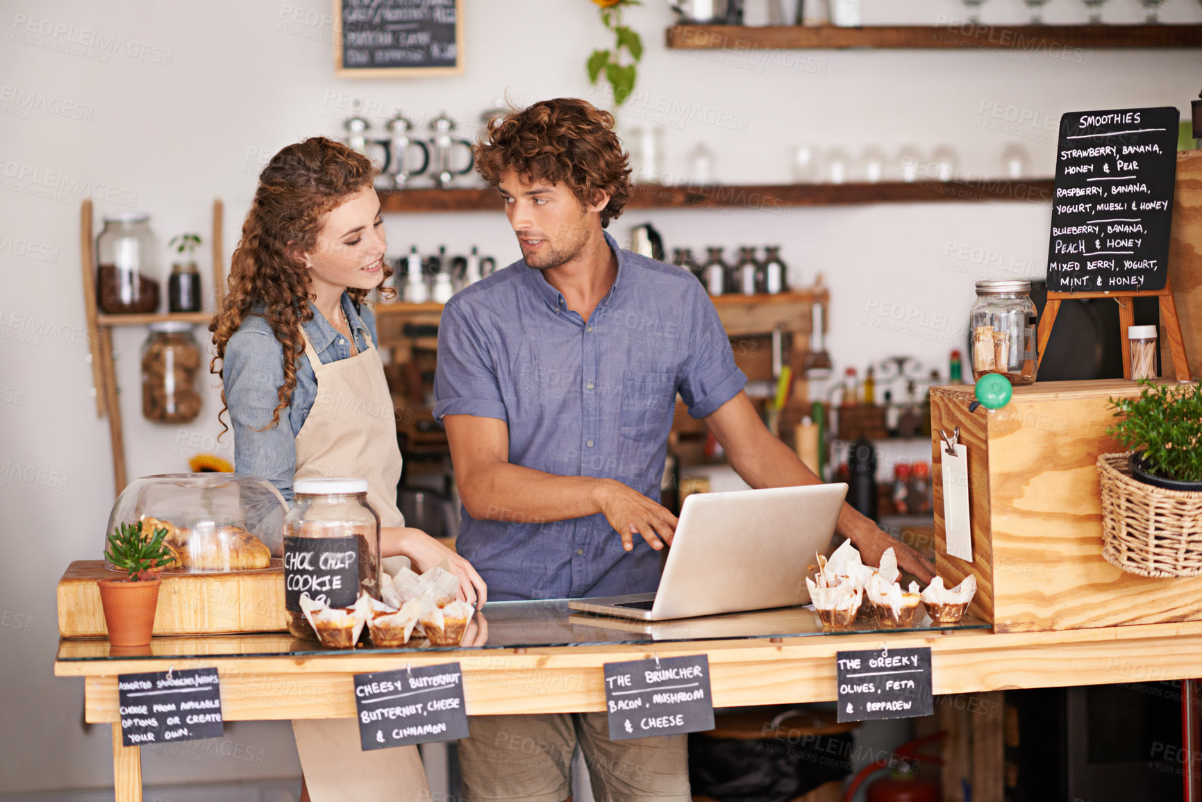 Buy stock photo Computer, bakery and small business people with team for  of sales, planning and advice in startup. Young woman and man or water in review for inventory, profit and e commerce on laptop at cafe