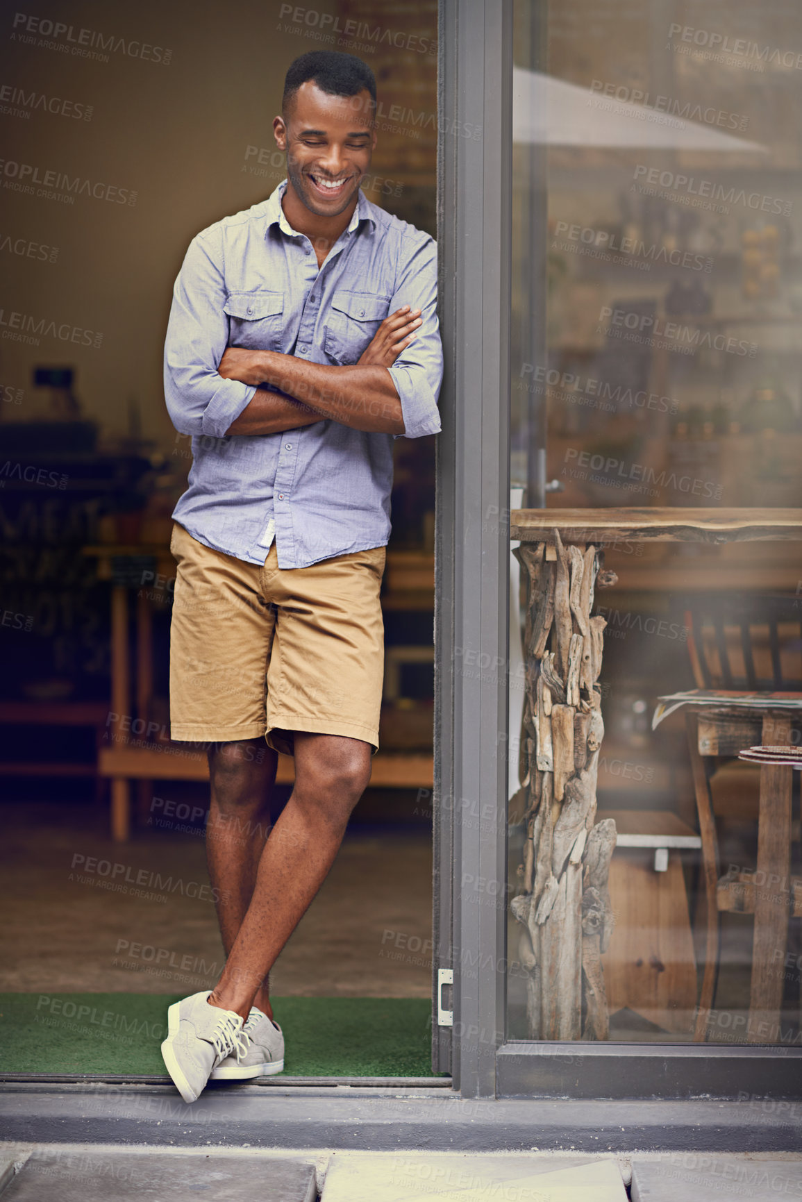 Buy stock photo Laughing, coffee shop and man as small business owner at front door with arms crossed. Black entrepreneur person as barista, manager or funny waiter in restaurant for service, thinking and goals