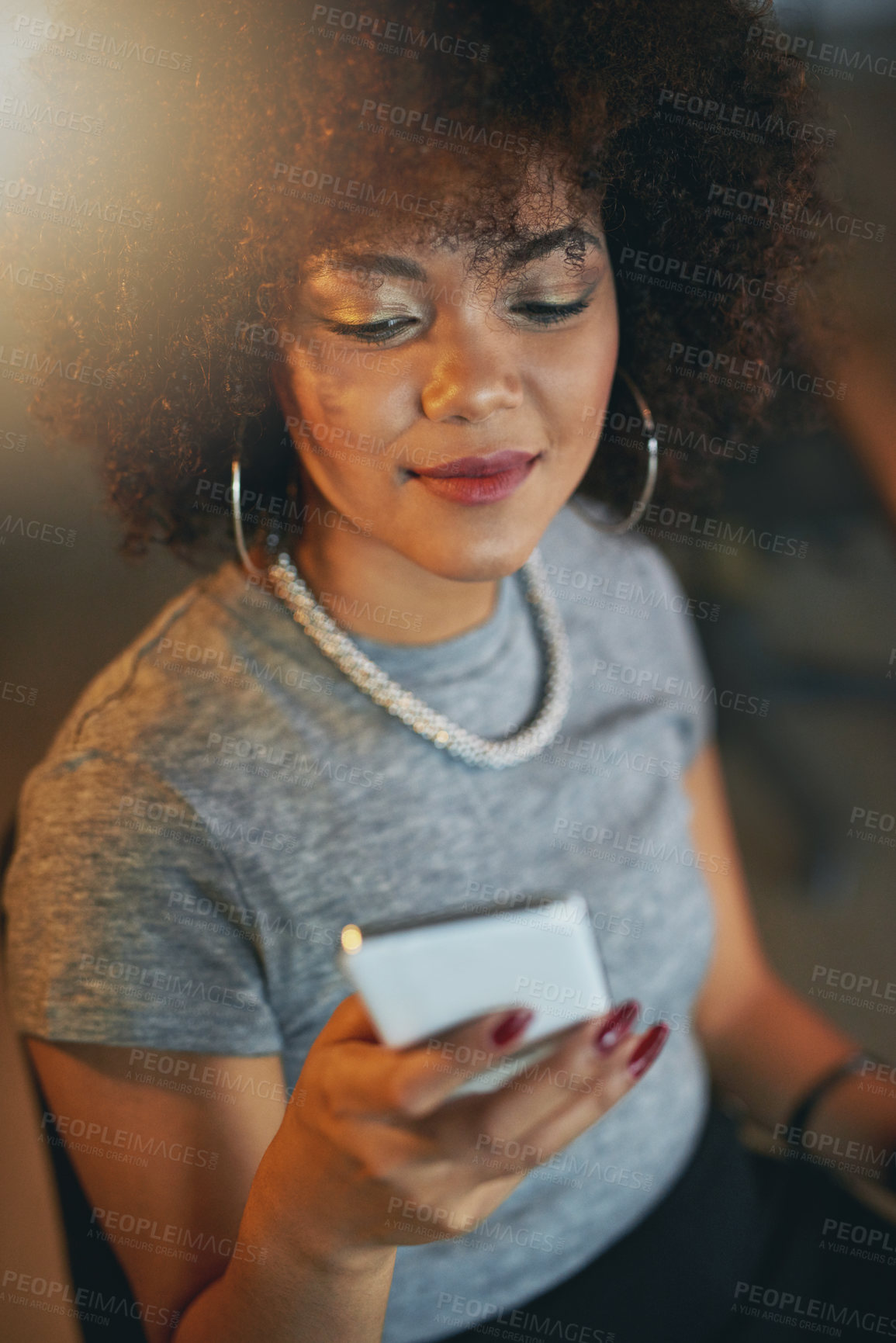 Buy stock photo Shot of a young woman using a phone during a late shift at the office