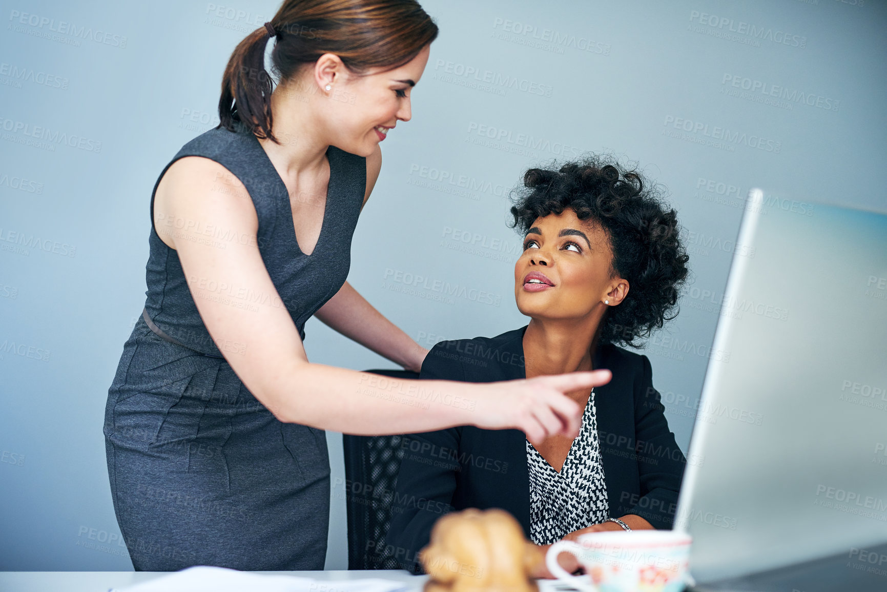 Buy stock photo Shot of two coworkers working together at a computer in an office