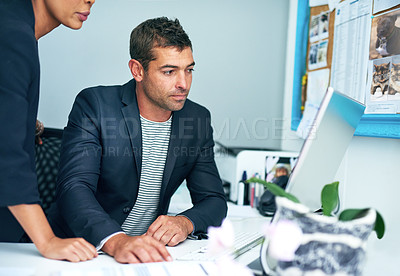 Buy stock photo Shot of two coworkers working together at a computer in an office