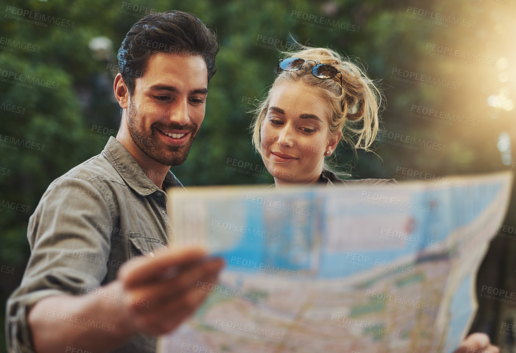 Buy stock photo Travel, couple and reading map in nature for adventure, holiday or directions in Budapest. Tourist, young woman and happy man with document for location, search destination or outdoor sightseeing