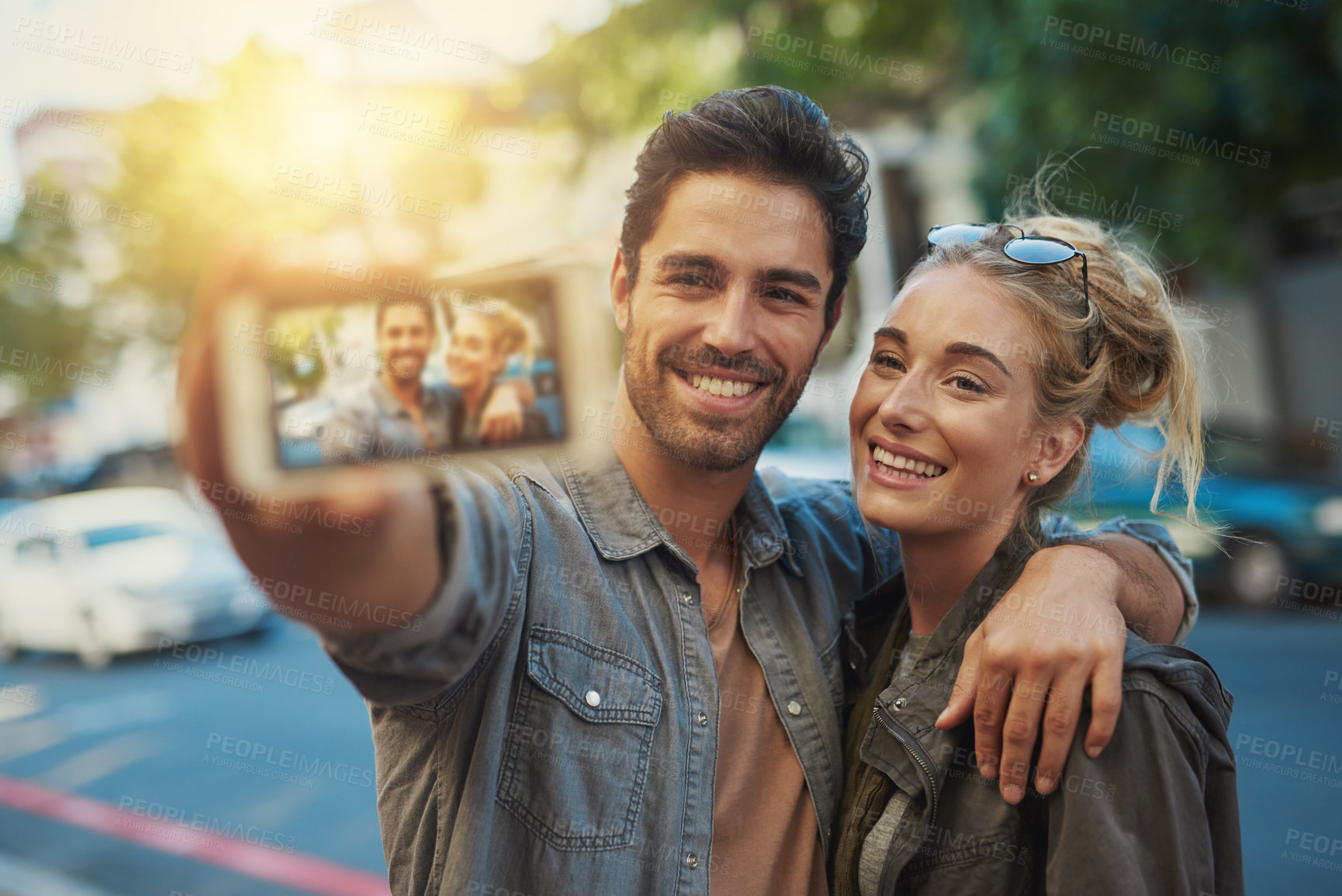 Buy stock photo Shot of a young couple taking a selfie in the city