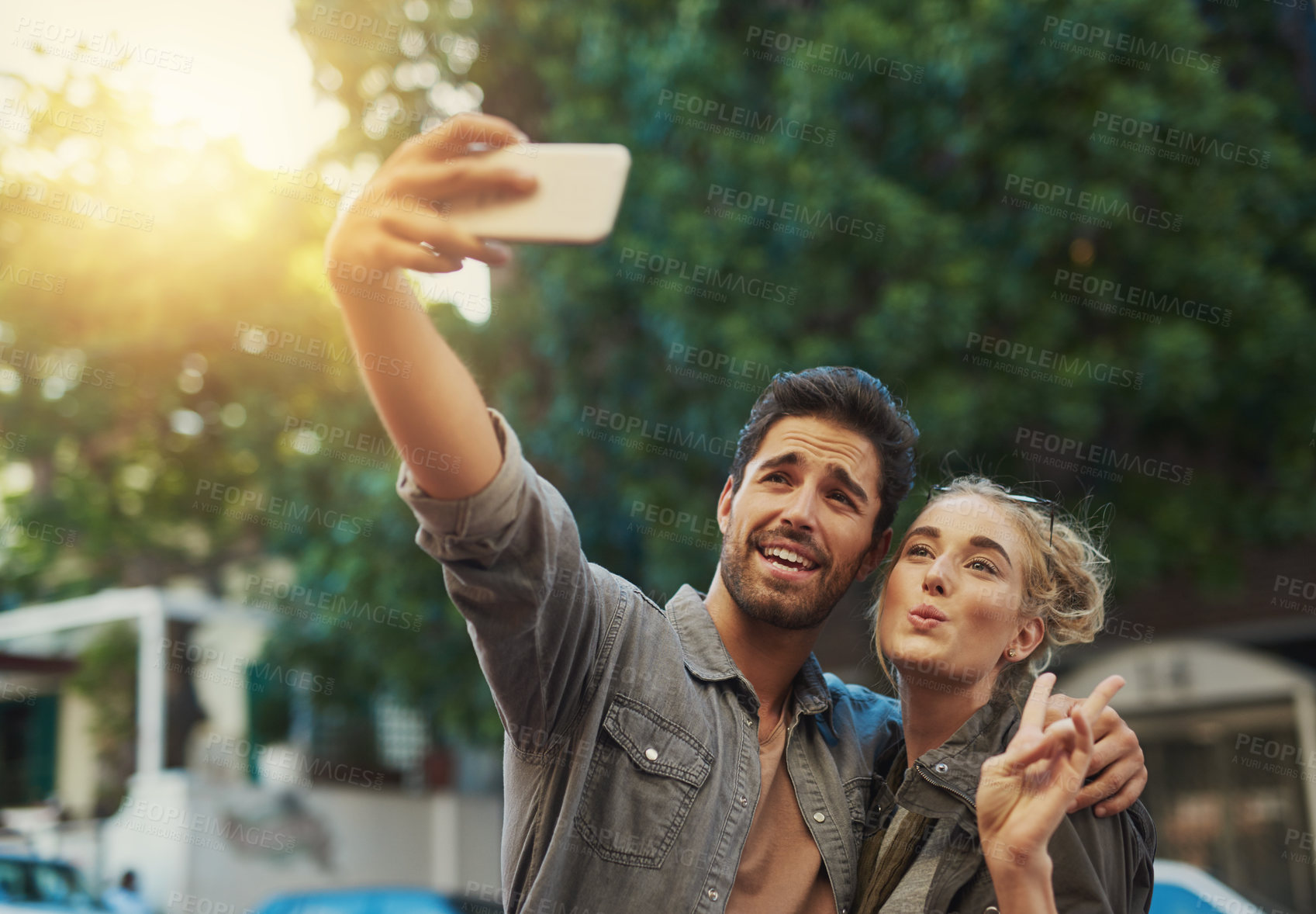 Buy stock photo Shot of a young couple taking a selfie in the city