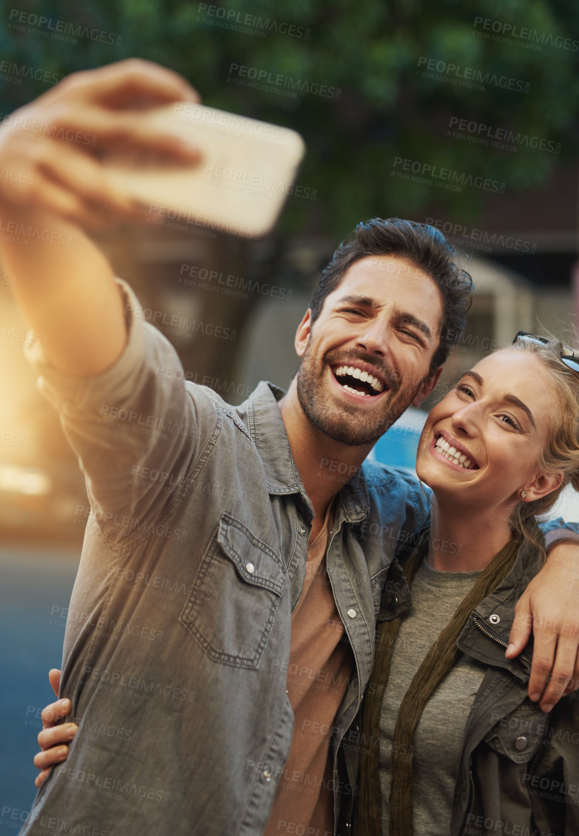 Buy stock photo Shot of a young couple taking a selfie in the city