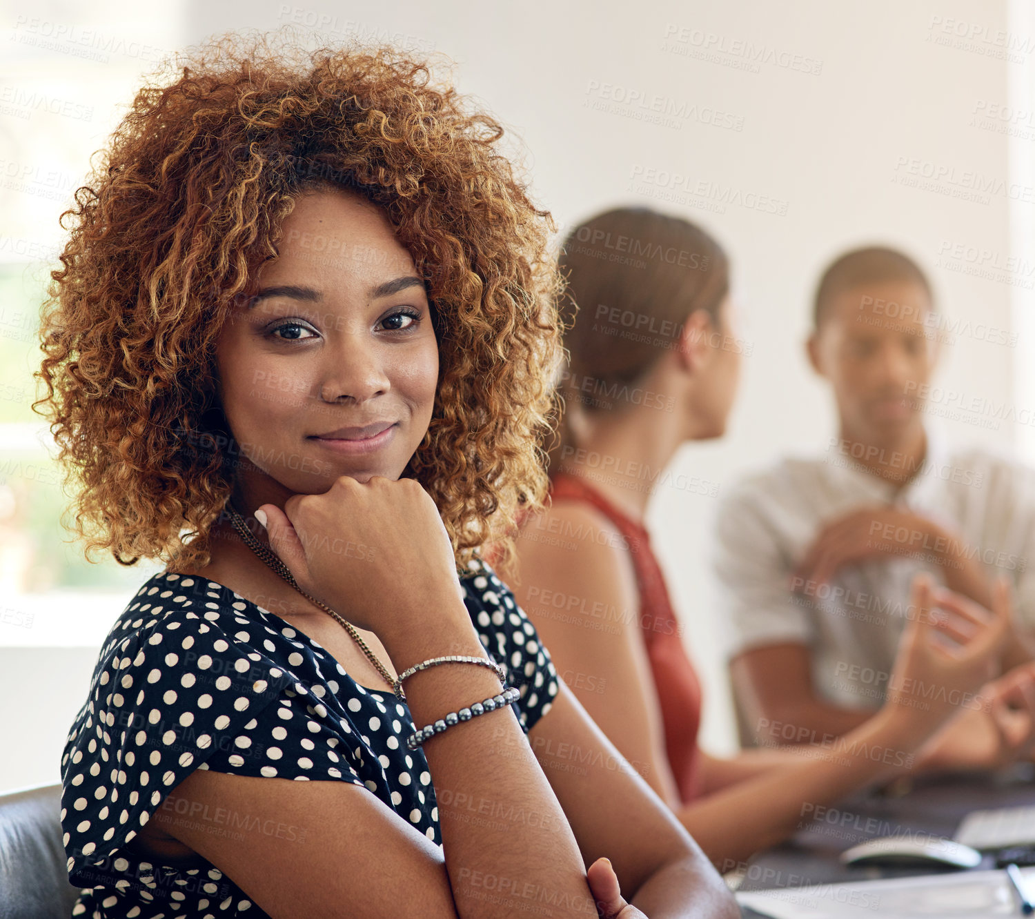 Buy stock photo Portrait of a smiling young designer sitting in an office with colleagues in the background