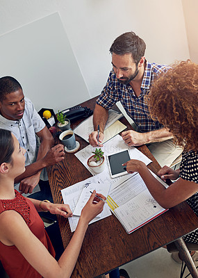 Buy stock photo Shot of a group of colleagues working together at a desk in an office