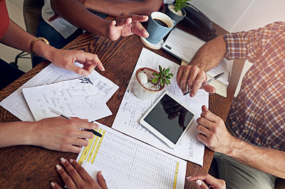 Buy stock photo Cropped shot of a group of colleagues working together at a desk in an office