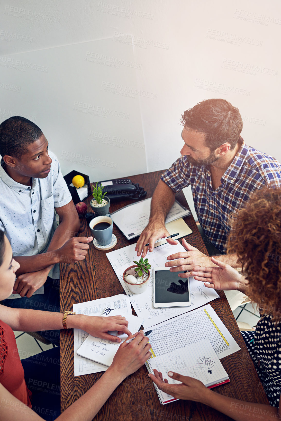 Buy stock photo Shot of a group of colleagues working together at a desk in an office