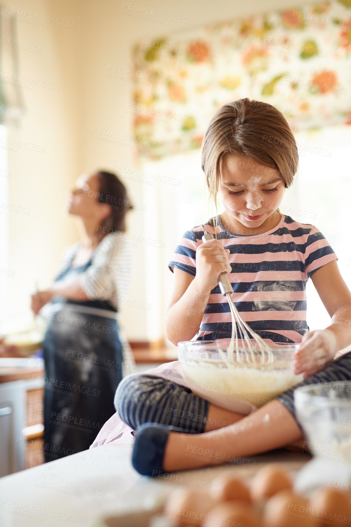 Buy stock photo Shot of a little girl helping her mom bake in the kitchen