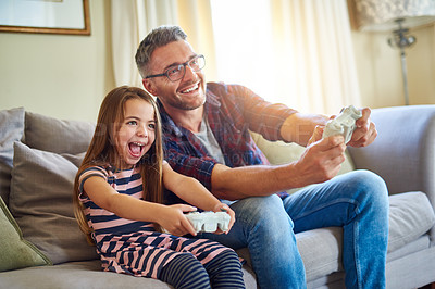 Buy stock photo Shot of a father and daughter playing video games