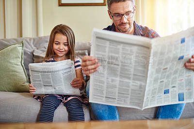 Buy stock photo Father, daughter and reading newspaper on sofa for knowledge, literature or news in living room at home. Happy dad, child and smile for family bonding, learning or education on lounge couch together
