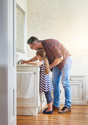 Buy stock photo Shot of a father helping his daughter to wash her hands