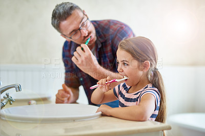 Buy stock photo Shot of a father and his daughter brushing their teeth
